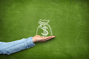 Money bag icon on blackboard with hand