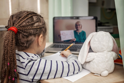 Pretty stylish schoolgirl studying math during her online lesson at home, social distance during quarantine, self-isolation, online education concept