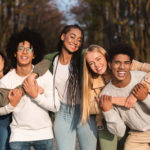 Positive group of young friends having fun at public park
