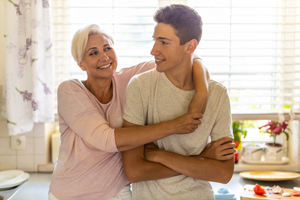 Mother hugging her teenage son in the kitchen