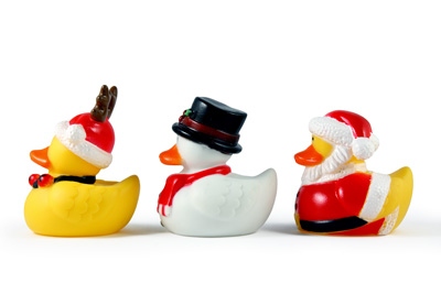 A set of 3 rubber duckies dressed in their Christmas best costumes. Shot on a solid white background.