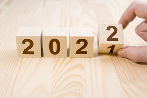 Man hand flipping cubes with year 2021 to 2022. new year concept. copy space. Hand holding wooden cube with flip over block 2021 to 2022 word on table background