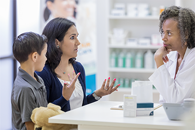 Parent with child talking to a pharmacist about ADHD meds / medication and substance use concerns.