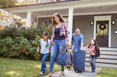 Family With Luggage Leaving House For Vacation